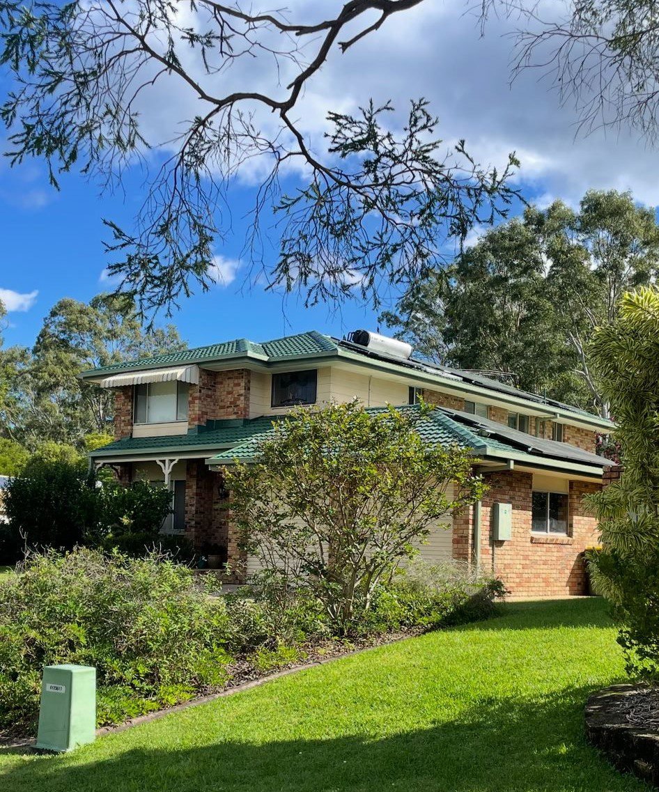 Two-storey home after a colour-change roof restoration in green