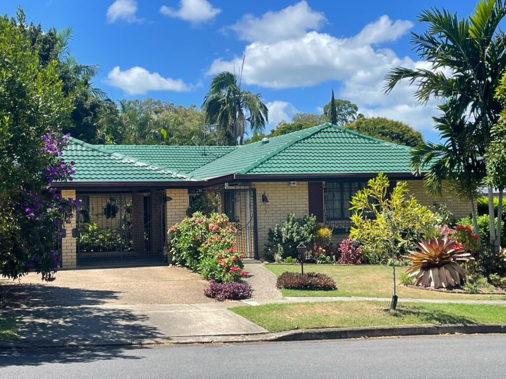 Single-storey Brisbane home with a restored green tile roof and painted fascia